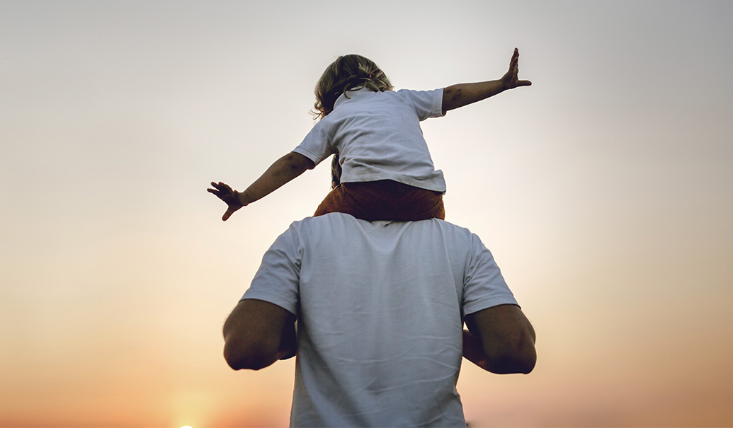 Dad-carries-baby-toddler-on-his-shoulders-at-sunset-in-field-thumbnail