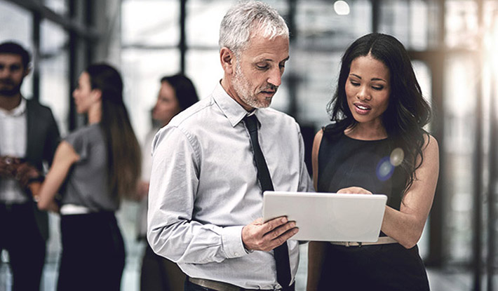 Colleagues discussing a project on a tablet 