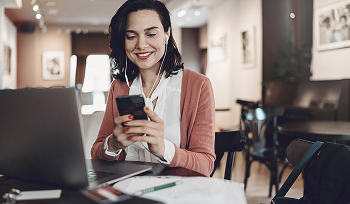 Businesswoman with laptop mobile headphones working in cafe