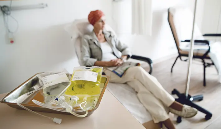Chemotherapy patient with treatment in foreground