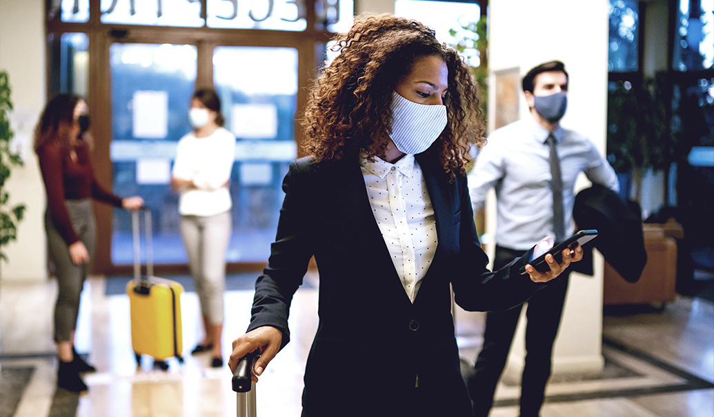 Hotel guests wearing protective face mask and social distance during COVID-19