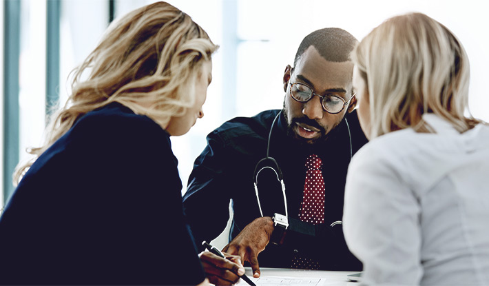 Male-doctor-talking-to-two-women