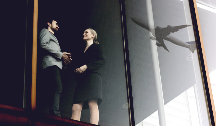 Two-business-people-airplane-reflected-on-window