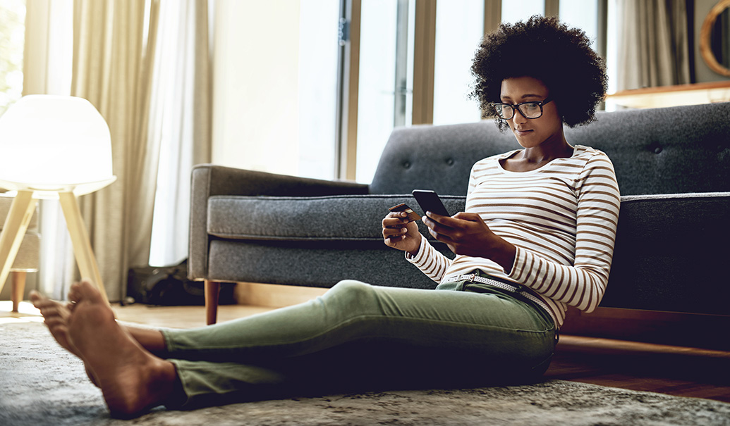 Woman sitting on floor looking at phone