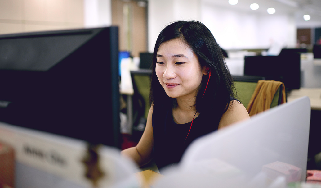 Woman working on computer with headphones