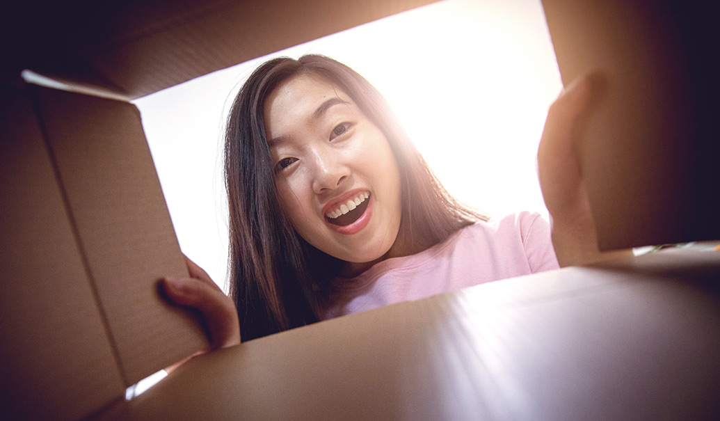 Young-woman-opening-a-parcel