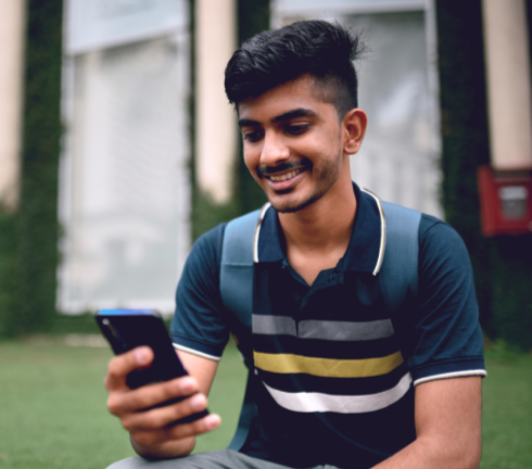 Student smiling while looking at phone
